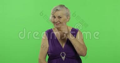 一位老妇人竖起大拇指，微笑着。 <strong>老奶奶</strong>。 铬键